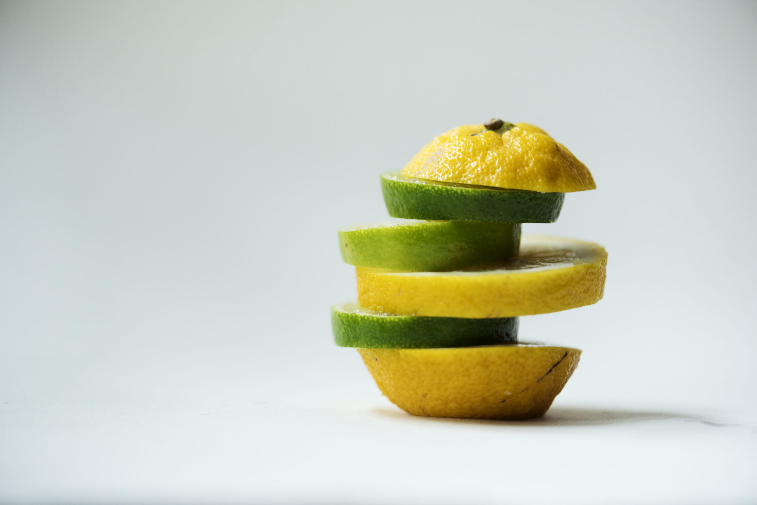 Closeup of oranges mixed with lime pieces isolated on white